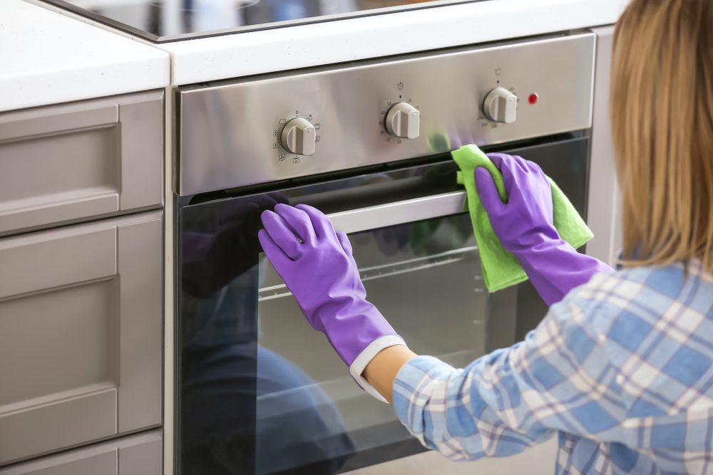 Woman Cleaning Her Stove Like A Cleaning Professional