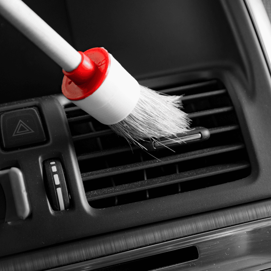 car vent being cleaned with a detailing brush 