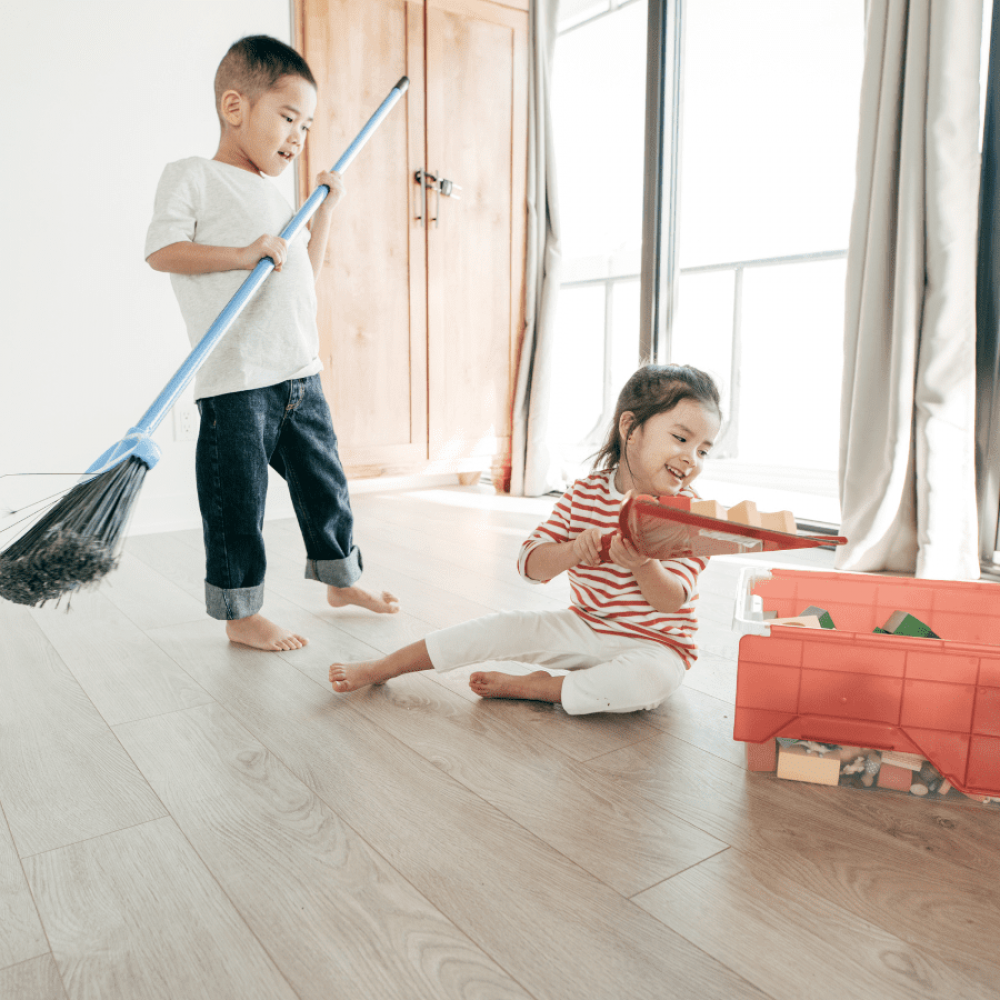 two kids working together to clean up