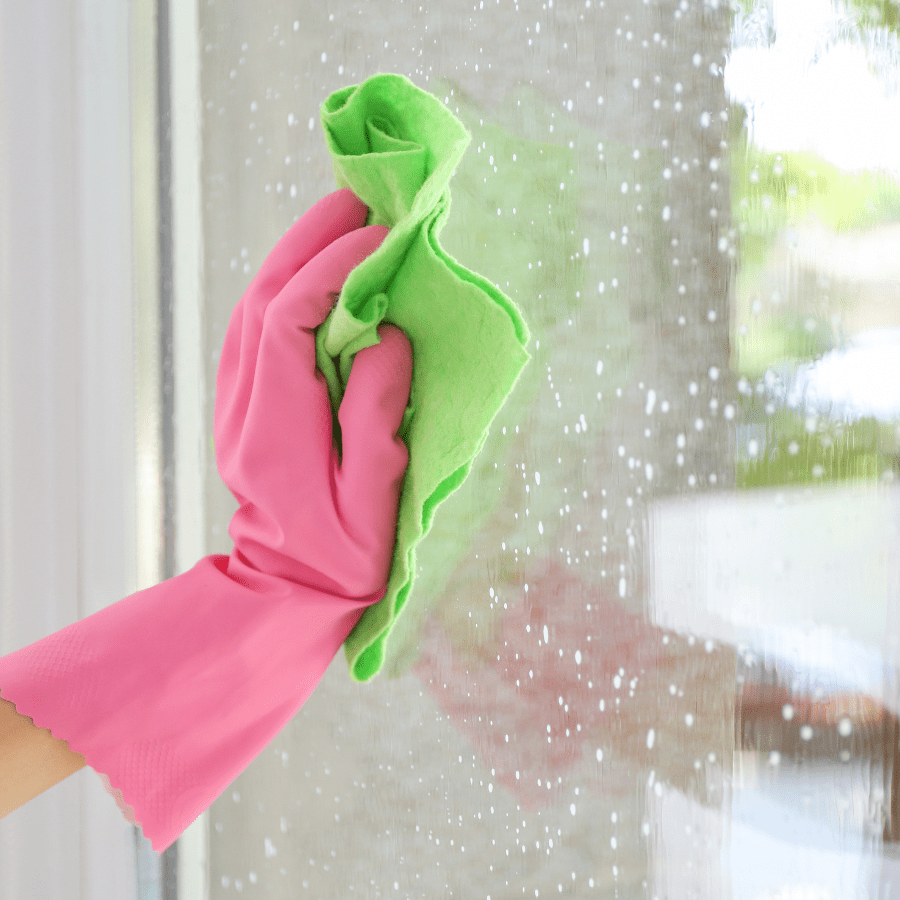 gloved hand wiping a window for streak free shine