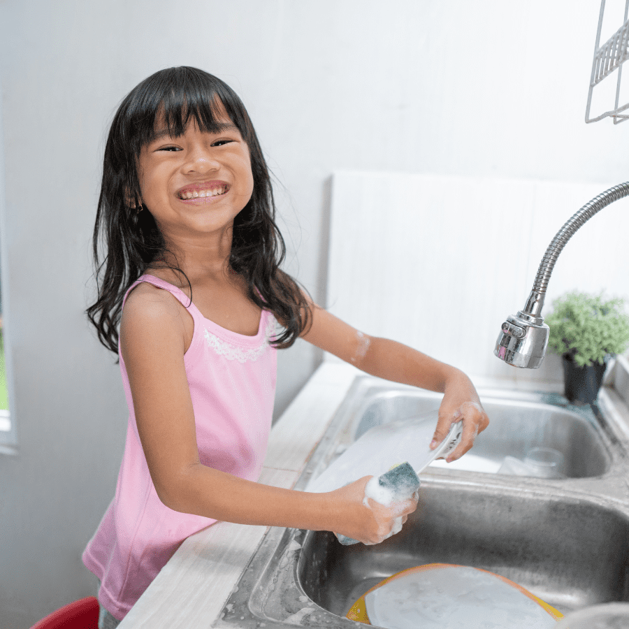 young girl happily doing dishes 