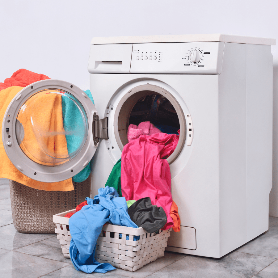 washing machine being loaded with clothing 