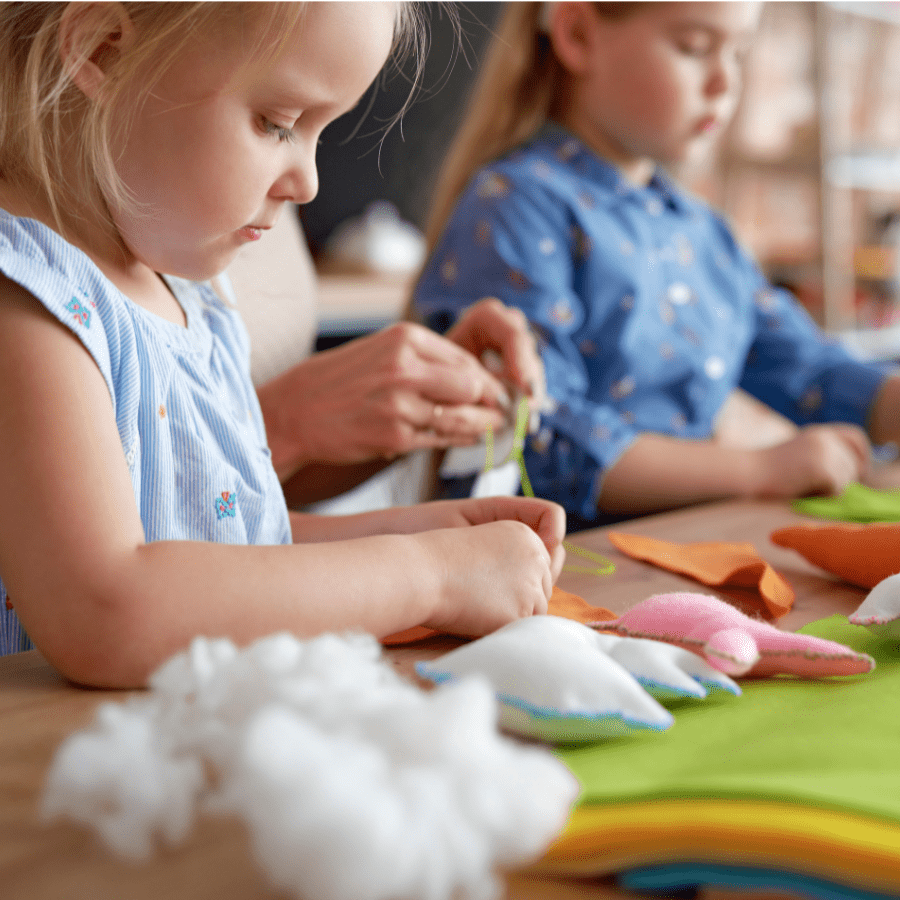 little kids doing crafts learning to sew stuffed animals 