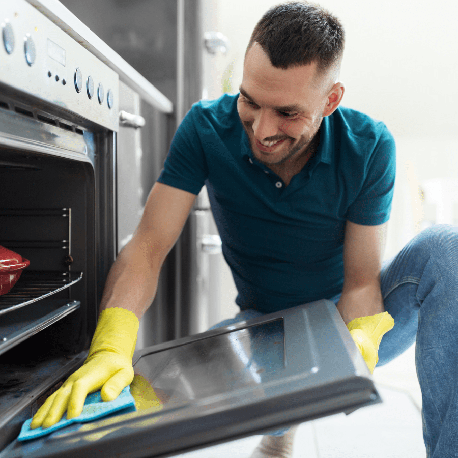 man cleaning oven easily after steaming it with a dishwasher tablet 