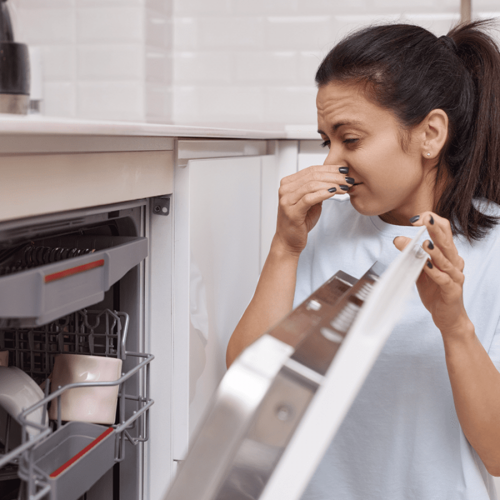 woman opening a smelly dishwasher